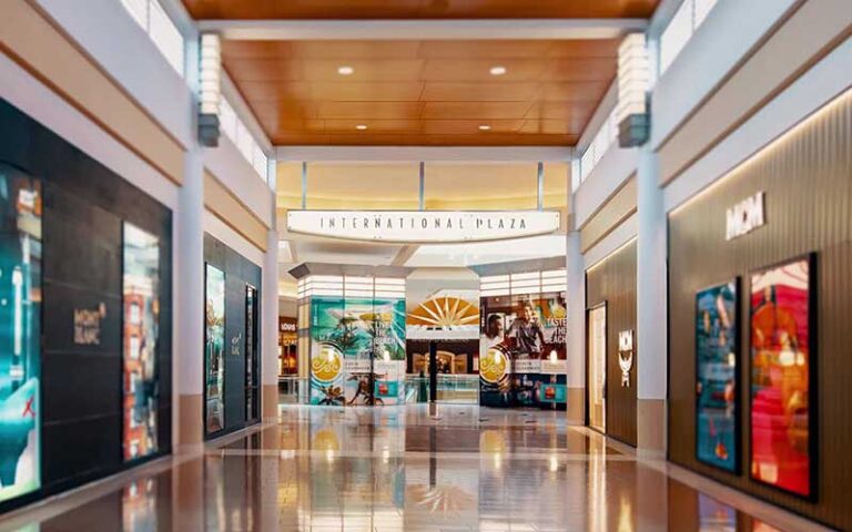 view down hallway of mall with storefronts and sign at international plaza and bay street tampa