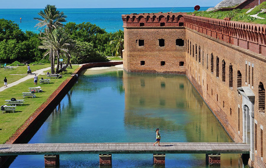 aerial view of front exterior fort jefferson with moat bridge picnic tables people at dry tortugas florida keys