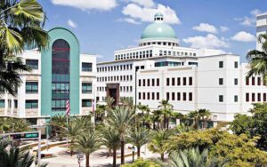 daytime building exterior with dome and palm trees courtyard at mandel public library of west palm beach