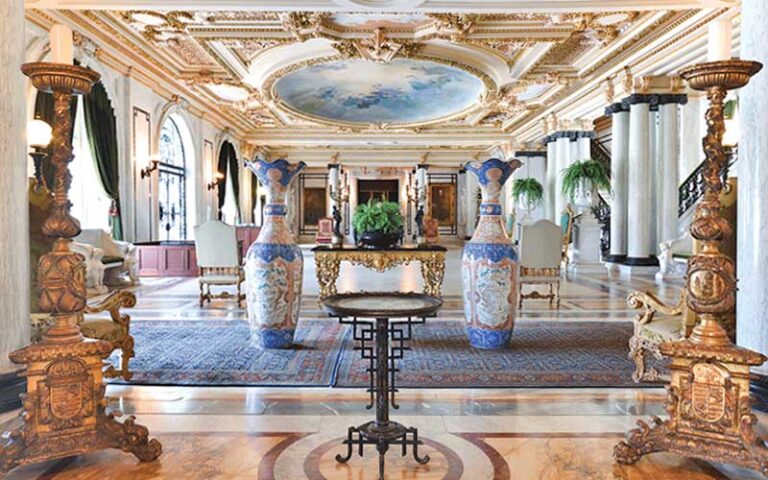 grand hall with marble columns and large vases at henry morrison flagler museum palm beach