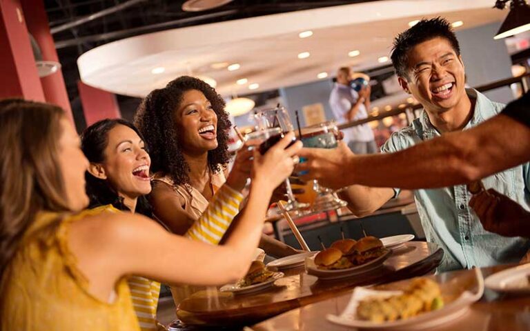 group of friends toasting and laughing over dining table at splitsville tampa