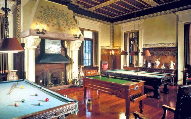 lodge style room with fireplace and billiards tables at henry morrison flagler museum palm beach