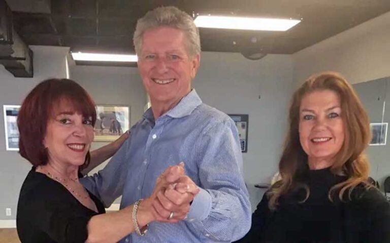 man with two women smiling at caruso dancesport west palm beach