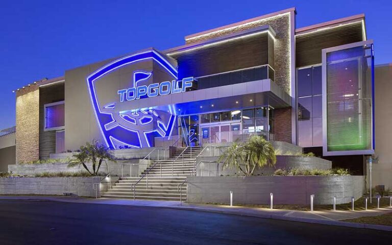 night exterior of building with sign and entrance at topgolf tampa