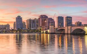 sunset sky over skyline of downtown with waterfront reflection at west palm beach