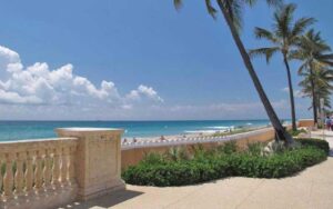 view from walkway over wall of beach with rolling waves at midtown municipal beach palm beach