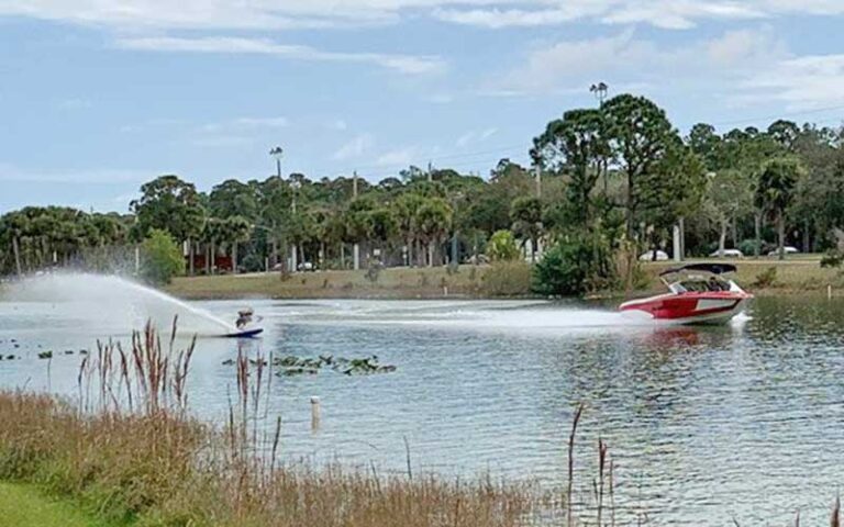 water skiing with red boat on lake at okeeheelee park west palm beach