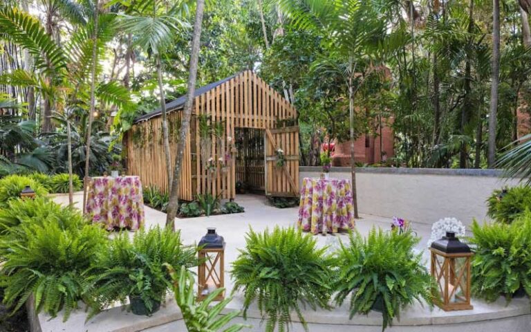 wood shed in garden plaza with palms and patio seating at ann norton sculpture gardens west palm beach