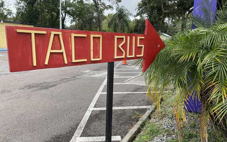 wooden sign pointing to alley food truck at taco bus tampa