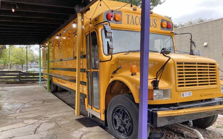 yellow school bus food truck with patio at taco bus tampa