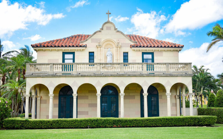 building with arched area statues and cross on top at st edward roman catholic church palm beach