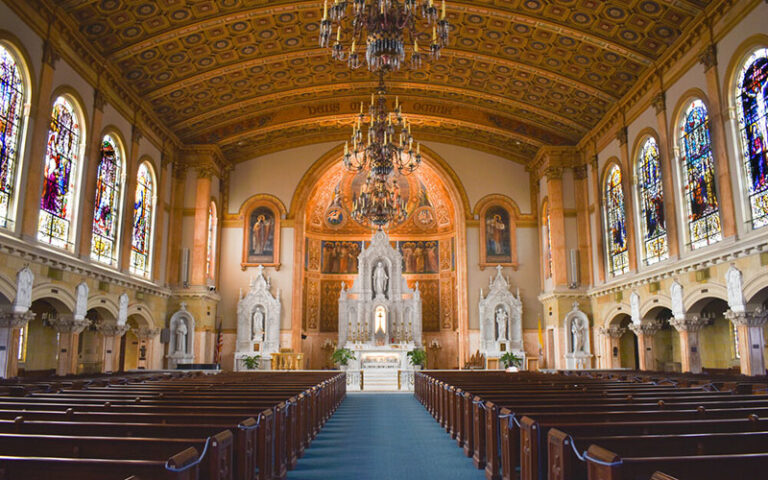cathedral interior with pews stained glass windows and chandeliers at st edward roman catholic church palm beach