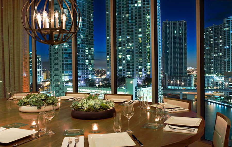 dining setting with panoramic windows showing downtown skyline at zuma miami