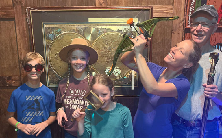 family with kids standing in front of maps at edge escape room kissimmee