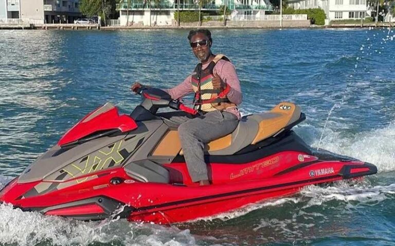 man smiling driving red jet ski on inlet at so flo water adventures miami