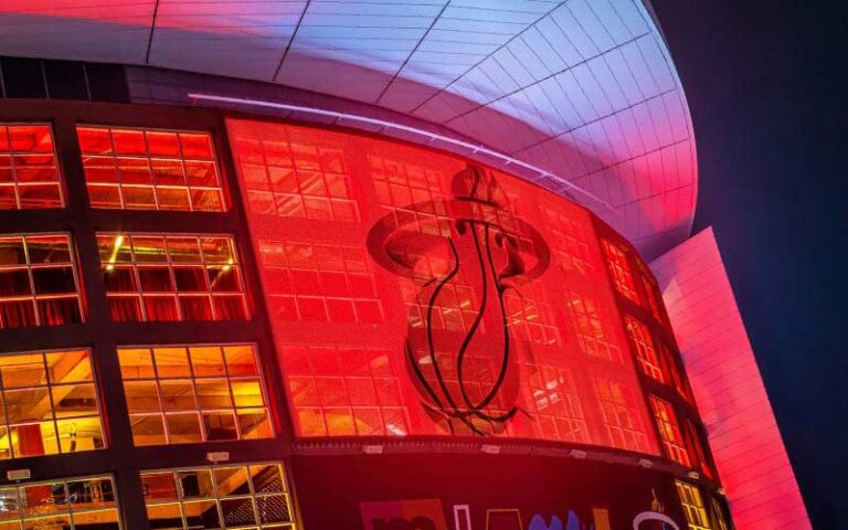 night view looking up at arena with miami heat logo sign on atrium windows at kaseya center miami