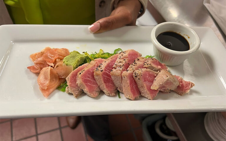 seared ahi tuna platter held by server at palm beach kennel club