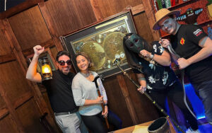 skewed view of couples in themed room with props at edge escape room kissimmee