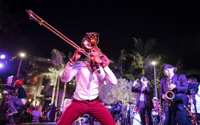 trombone performer with band in night outdoor jazz event at the square west palm beach