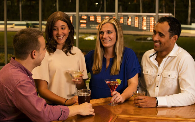 two couples having drinks and talking at palm beach kennel club