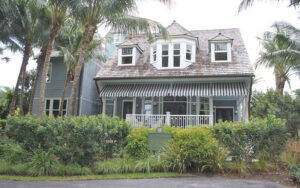 victorian style home with awnings palm trees and historical marker at sea gull cottage palm beach