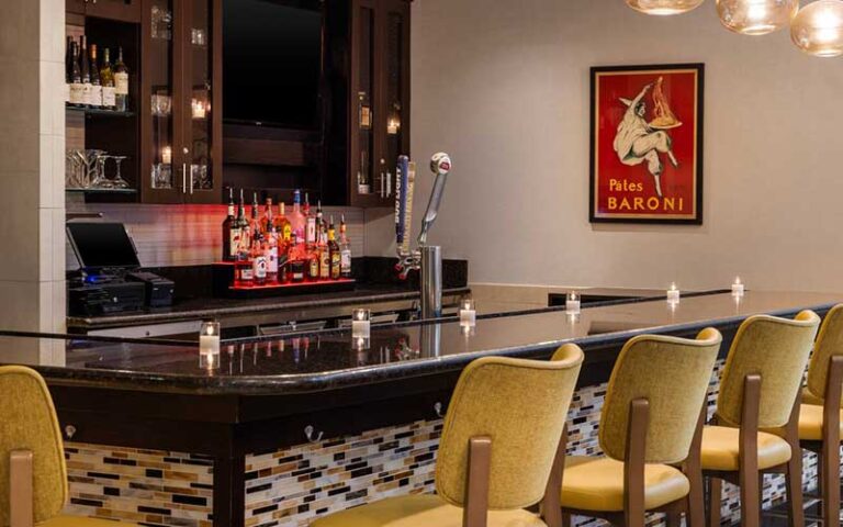 bar area with yellow seats and red artwork at hilton garden inn west palm beach airport at hilton garden inn west palm beach airport