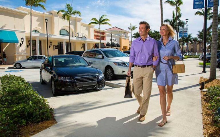 couple shopping walking between parking and stores at delray marketplace palm beaches