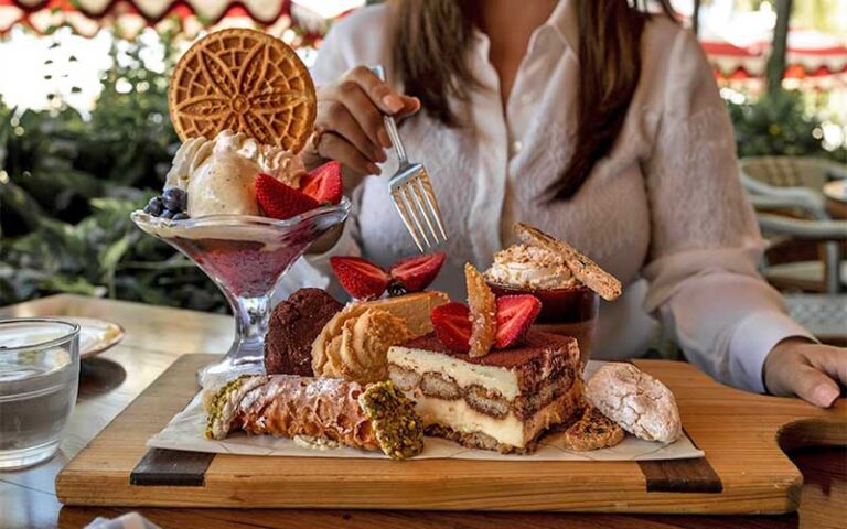 dessert platter with italian pastries and woman with fork at elisabettas ristorante west palm beach