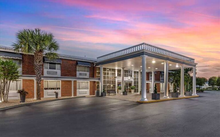 front twilight exterior of hotel with covered dropoff at best western palm beach lakes