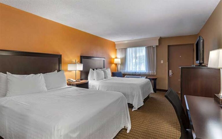guest room with two beds and orange accents at best western palm beach lakes