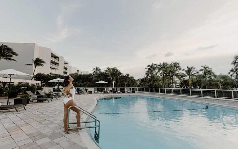 hotel pool area with woman at the ambassador palm beach hotel residences