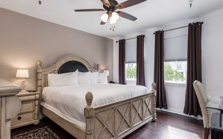 king size bed guest room with brown accents at palm beach historic inn