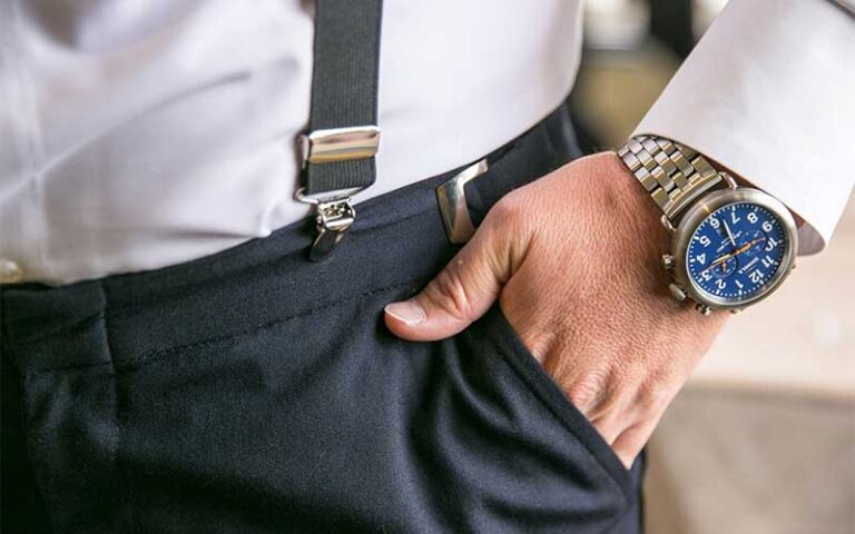 man with hand in pocket showing watch pants and suspenders at tux shop palm beach