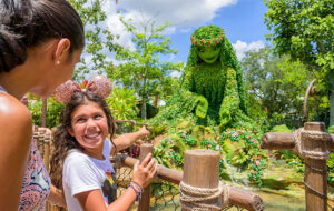 mom and daughter look at statue of te fiti in moana themed garden area at epcot walt disney world resort