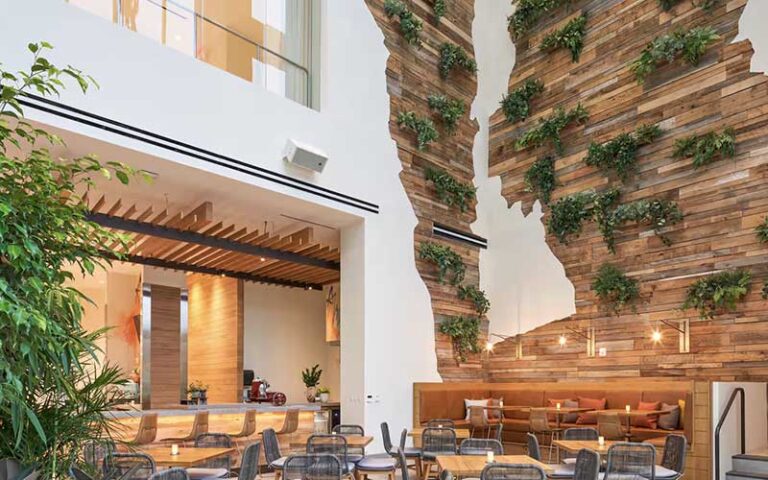 multi story atrium dining area with wood and planters on walls at canopy by hilton west palm beach downtown