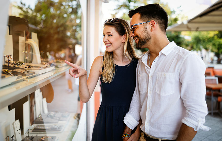 nicely dressed couple looking at jewelry in shop window at worth avenue palm beach