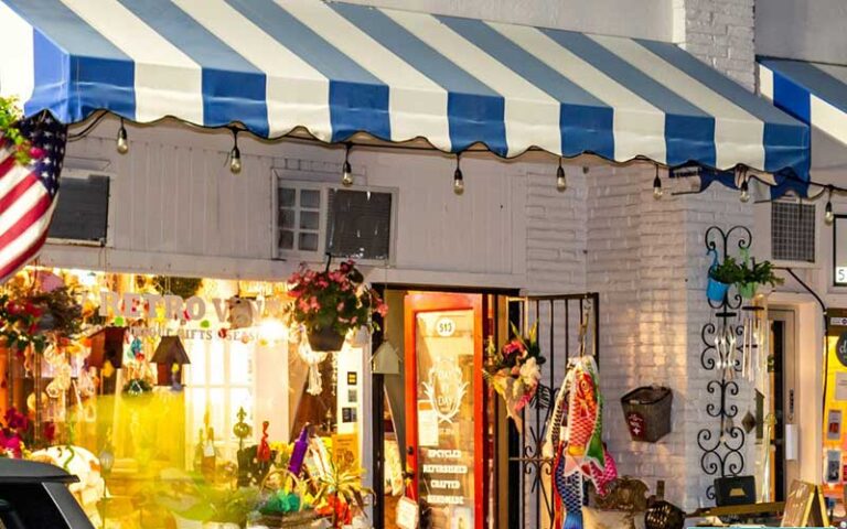 night exterior shop with blue and white awning at northwood village west palm beach