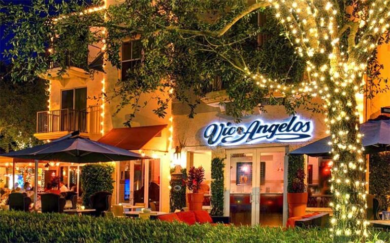 night view across lighted trees of restaurant at pga commons art dining district palm beach gardens