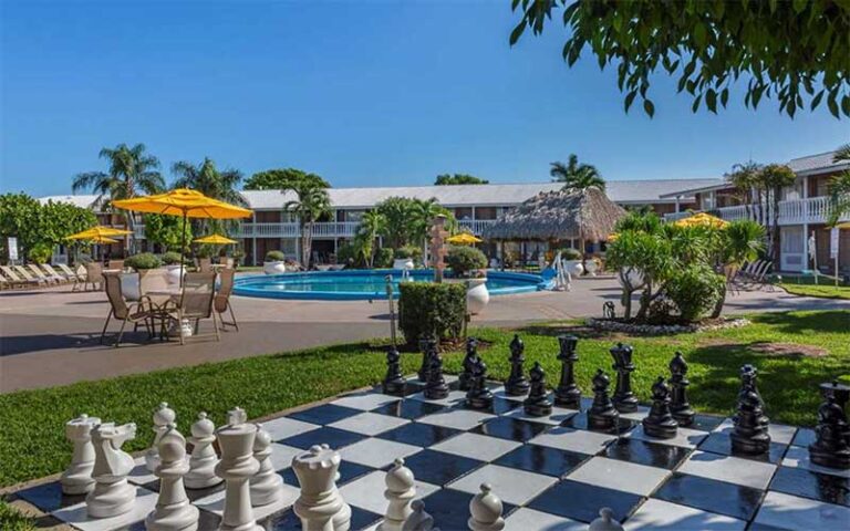 patio pool area with giant chess set and trees at best western palm beach lakes