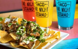 row of colorful drinks and platter of asada nachos at one night taco stand jacksonville