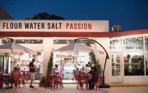 sidewalk dining at night exterior of cafe with painted words flour water salt passion at lynoras kitchen west palm beach