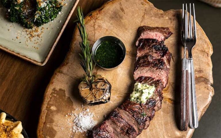 steak sliced and spread out on wood plank with sides at galley west palm beach