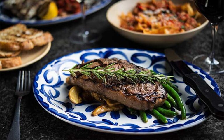 steak with asparagus entree with other sides and wine at mias italian kitchen orlando