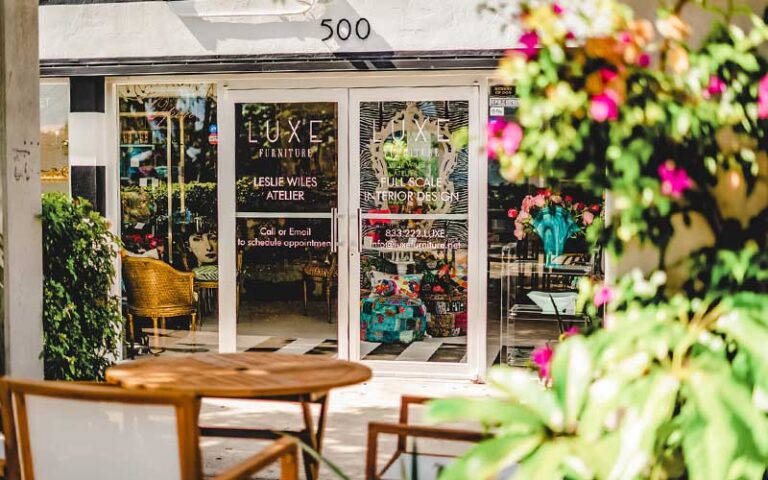 storefront with flowering shrubs and tables at northwood village west palm beach