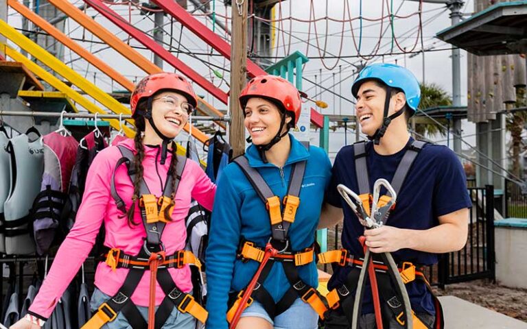 three young friends laughing in ropes course gear at nona adventure park orlando