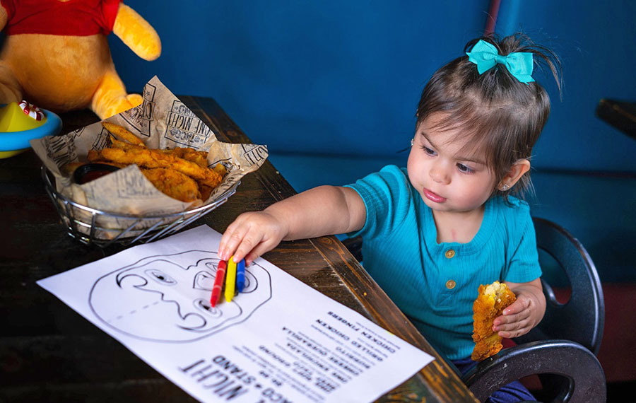 toddler girl coloring page with taco in hand at one night taco stand jacksonville