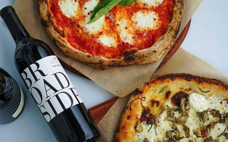 two gourmet pizzas with red wine bottle at grandview public market west palm beach