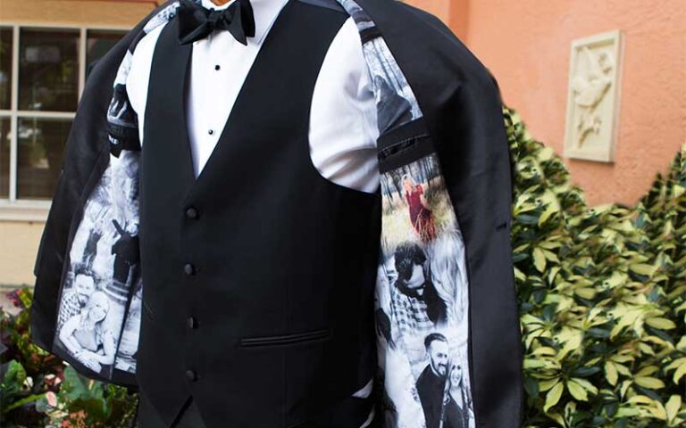 upper torso of man showing images inside suit jacket lining at tux shop palm beach