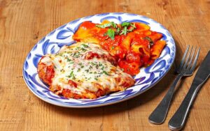 veal parmigiana with pasta plated on tabletop at mias italian kitchen orlando