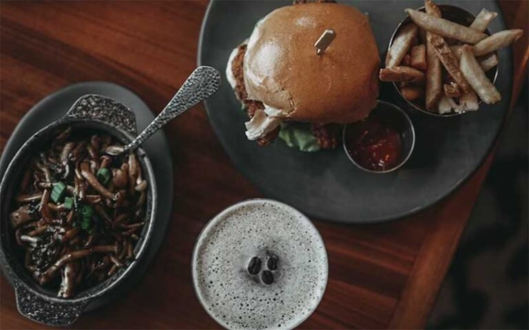 view from above of burger entree with sides and drink at proper grit west palm beach